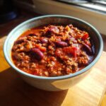 A hearty bowl of Best Chili Con Carne, featuring rich ground beef, kidney beans, and tomatoes.