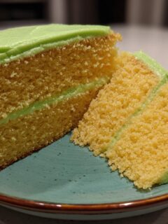 A slice of moist Key Lime Cake with vibrant green frosting, showing the cake's texture and layers.