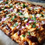 Close-up of a delicious Quick Bbq Chicken Flatbread topped with shredded chicken, red onions, melted cheese, and cilantro.