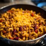 Close-up of Quick Chili Mac With Ground Beef in a pan, topped with shredded cheese.