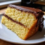 A delicious slice of yellow cake with rich mocha frosting, showcasing the cake's texture and frosting swirls.