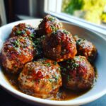 Close-up of glazed Crockpot Meatballs covered in savory sauce and sprinkled with fresh parsley.