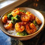 A close-up of a Honey Garlic Shrimp Bowl featuring glossy shrimp and bright green broccoli over white rice.