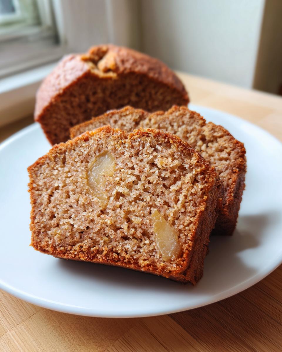 Close-up of moist slices of Spiced Pear Cake showing chunks of pear baked into the brown crumb.