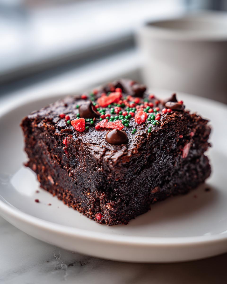 A rich, fudgy square of Christmas Brownies topped with red and green sprinkles and chocolate chips.