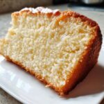 Close-up of a fluffy, golden-crusted slice from one of our Vegan Cake Recipes on a white plate.