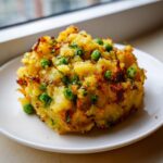 Close-up of a mound of spiced potato and pea mixture, a popular Samosa Filling Idea, on a white plate.