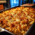 A close-up of a baked Chicken Noodle Casserole with a golden, crispy breadcrumb topping and herbs.
