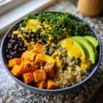 A vibrant Anti Inflammatory Glow Bowl featuring roasted sweet potatoes, black beans, kale, quinoa, avocado, and pumpkin seeds.