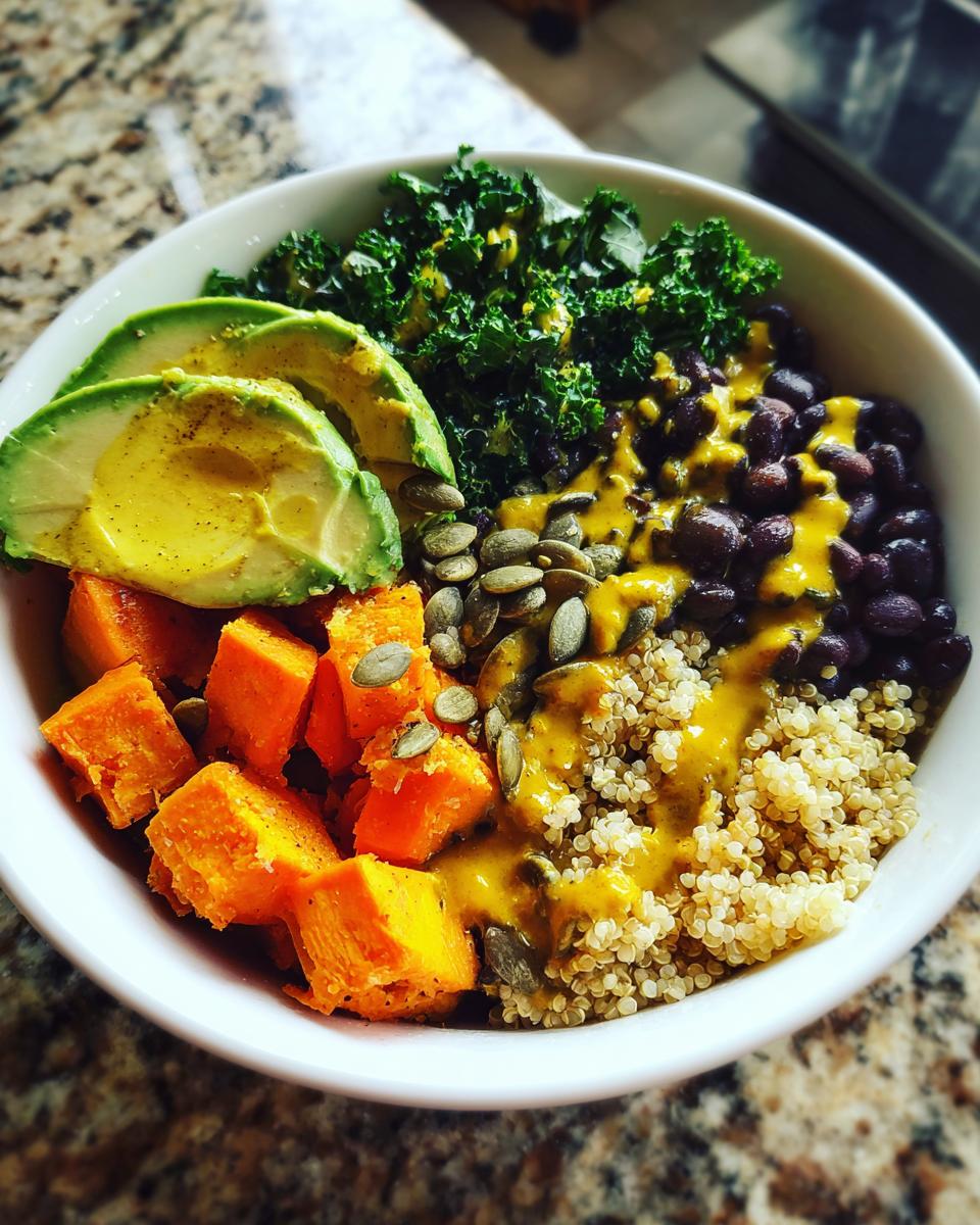 Overhead view of a vibrant Anti Inflammatory Glow Bowl featuring quinoa, black beans, sweet potato, kale, and avocado.