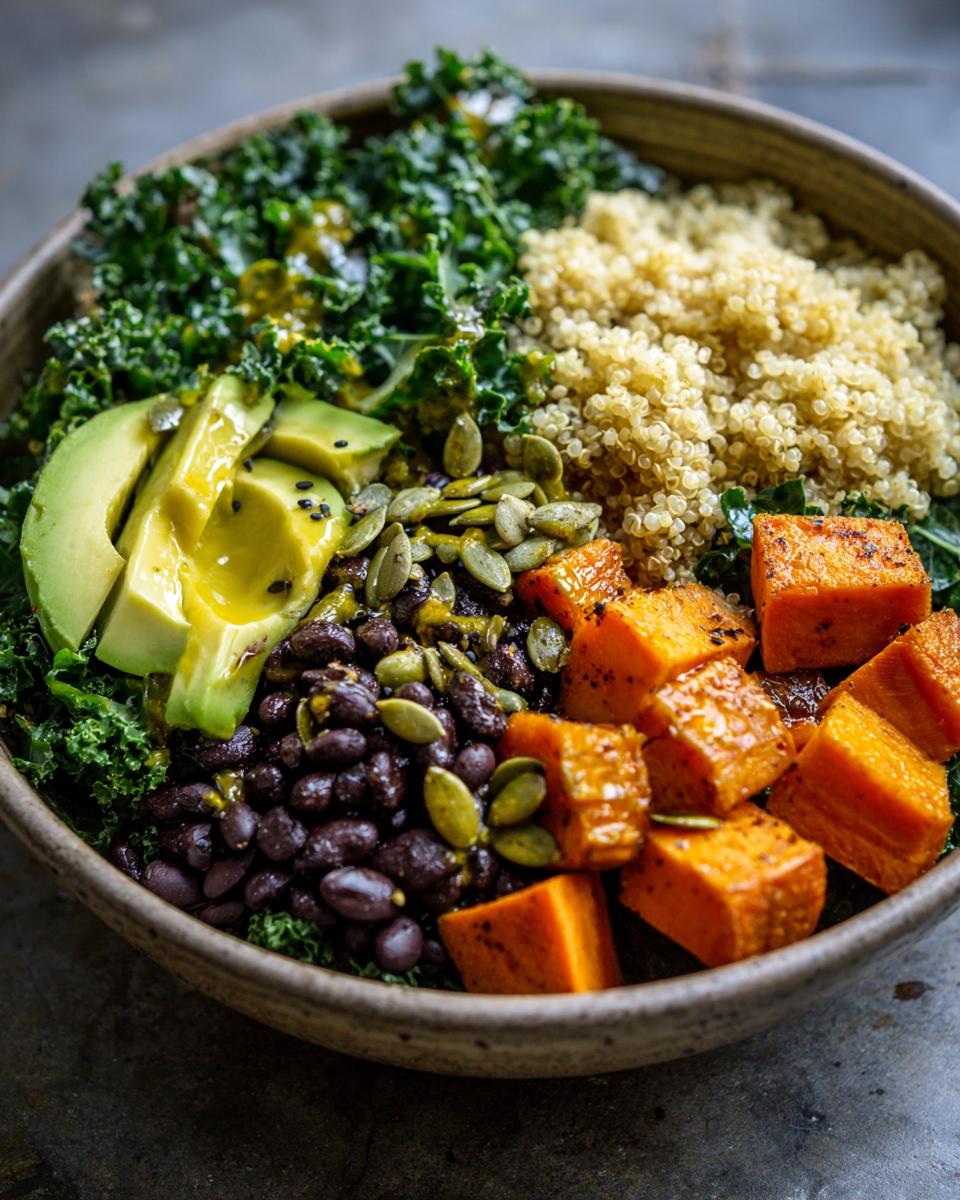 Close-up of a vibrant Anti Inflammatory Glow Bowl featuring kale, quinoa, avocado, black beans, and roasted sweet potato.