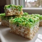 Close-up of layered Frankenstein Rice Krispie Bars showing a white bottom layer and a vibrant green top layer.