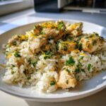 Close-up of Lemon Herb Chicken And Rice topped with fresh parsley and lemon zest.