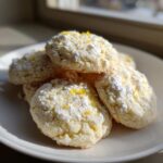 A stack of Lemon Lavender Shortbread Cookies dusted with powdered sugar and lemon zest.