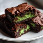 Close-up of fudgy Monster Mash Brownies showing a bright green layer and chocolate chips inside.
