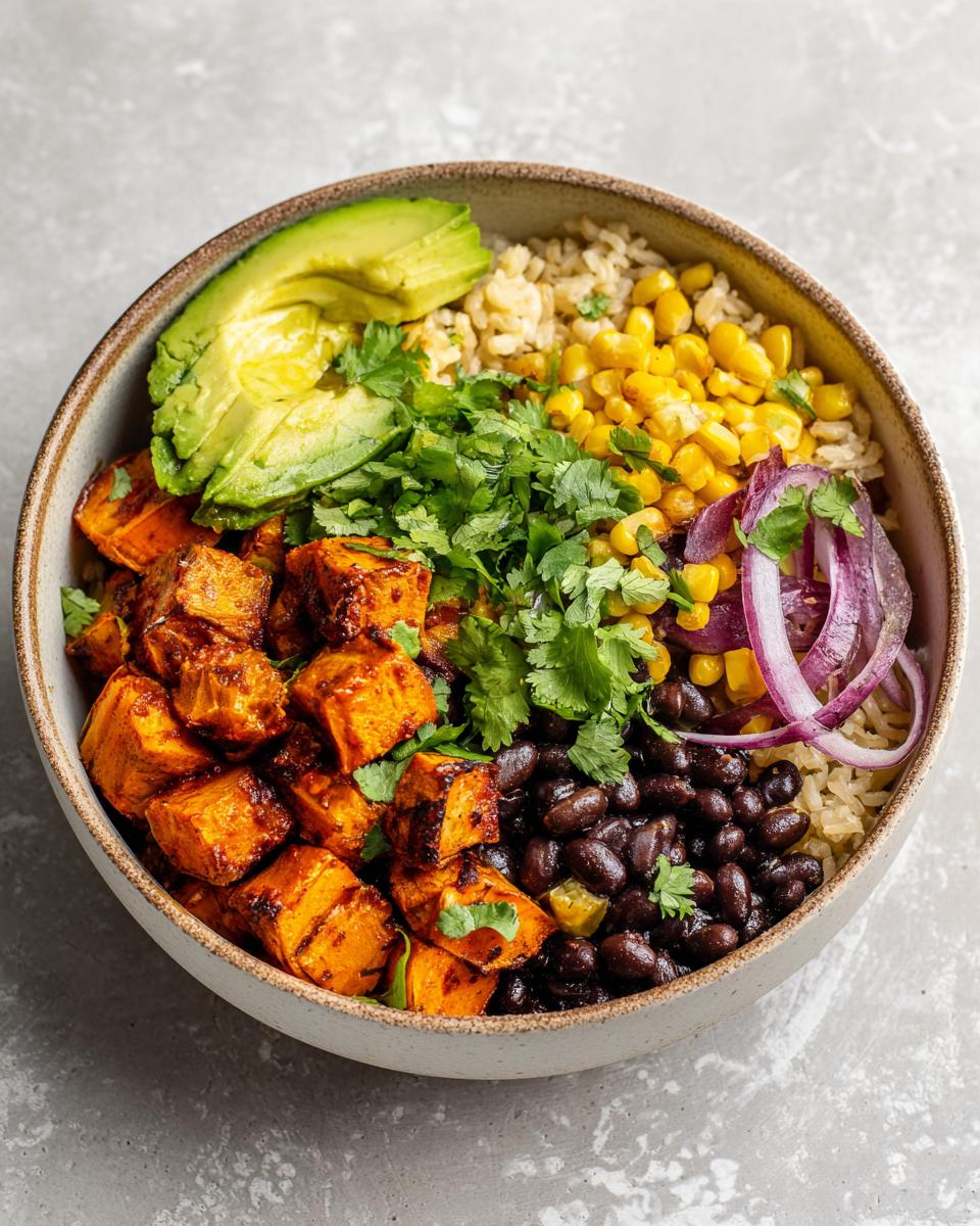 A vibrant Sweet Potato Taco Bowl featuring seasoned sweet potatoes, black beans, corn, avocado, and cilantro.