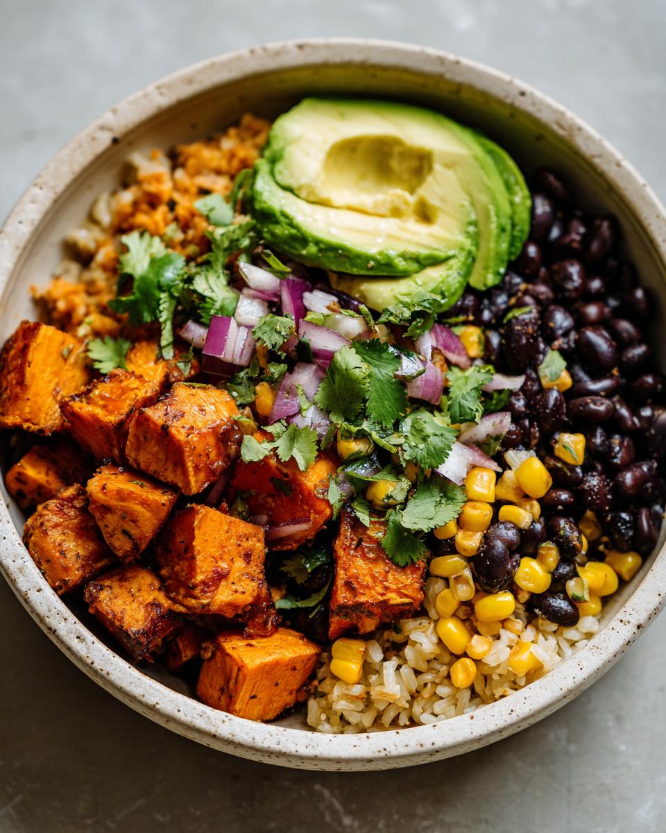 A vibrant Sweet Potato Taco Bowl featuring roasted sweet potatoes, black beans, corn, avocado slices, and cilantro.