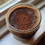 Overhead view of Tiramisu Chia Pudding in a glass jar, generously dusted with cocoa powder.