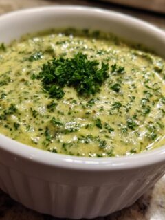 Close-up of creamy green Witch Brew Salsa Verde Cream Dip topped with fresh parsley in a white bowl.