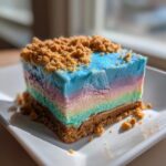 A square slice of colorful, layered Mermaid Ice Cream with a graham cracker crust and crumb topping.